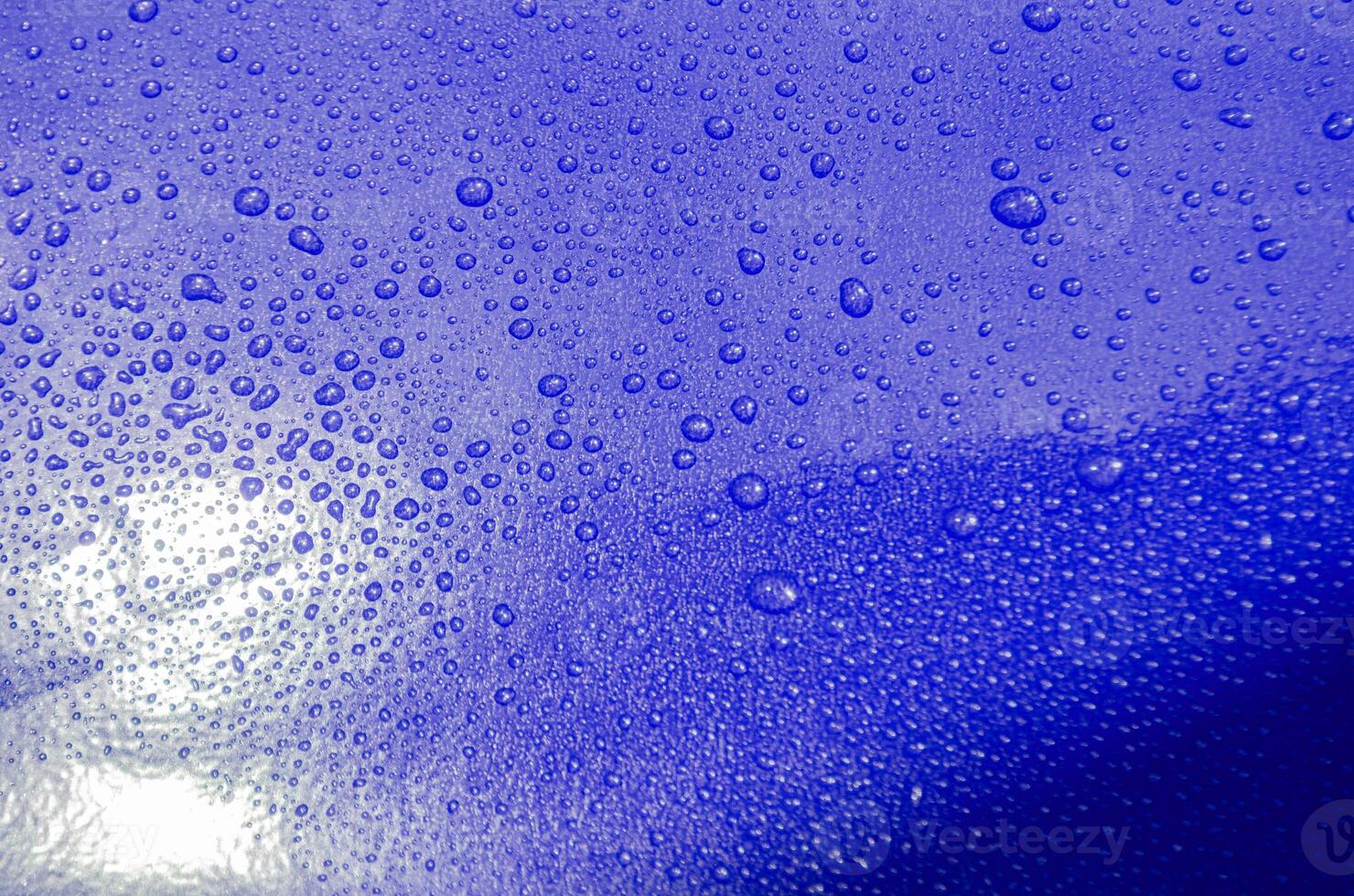 Rain water droplets with bright blue color background suitable for wallpaper photo