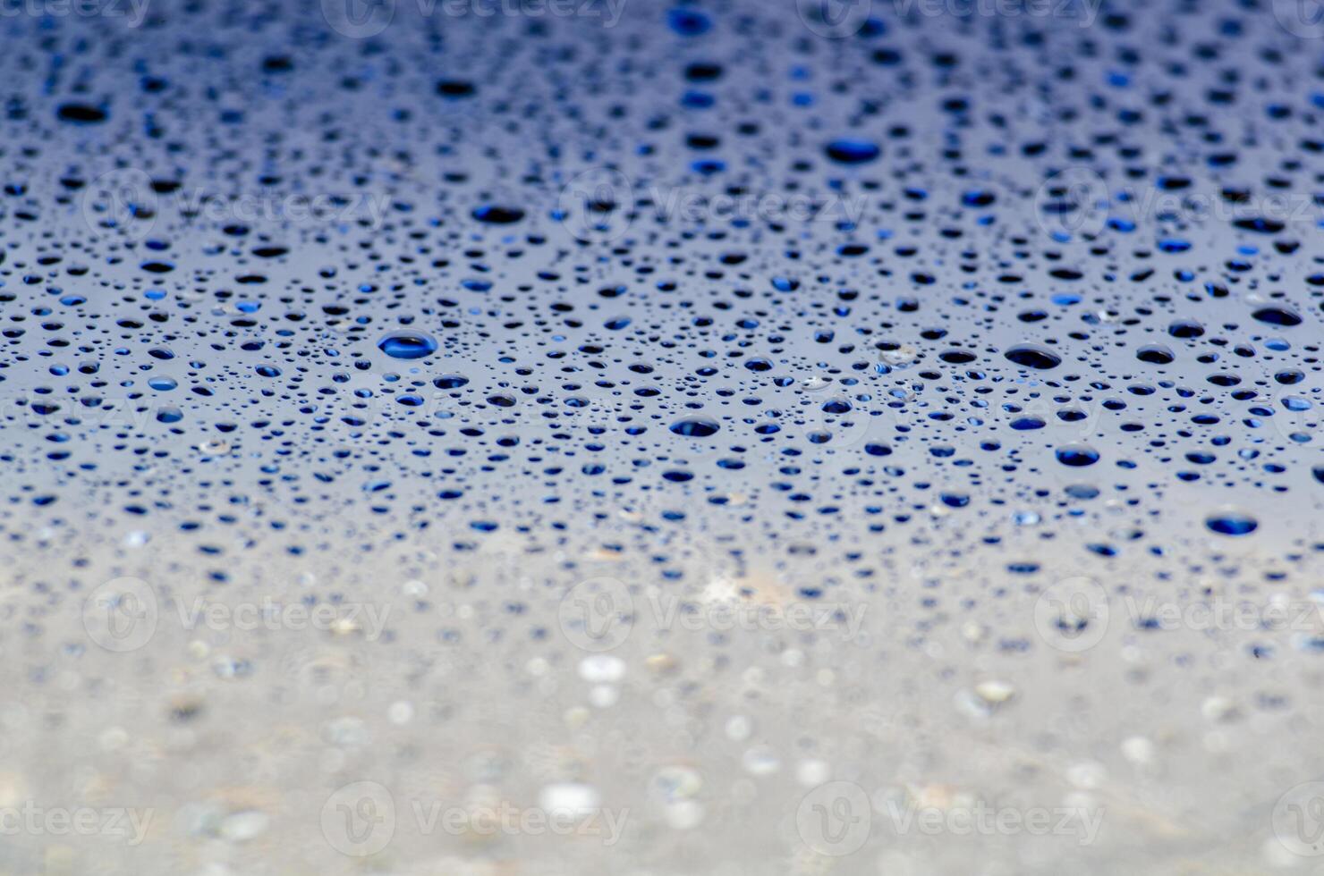 Water droplets on a dark blue ocean color background with customizable space for text or ideas photo