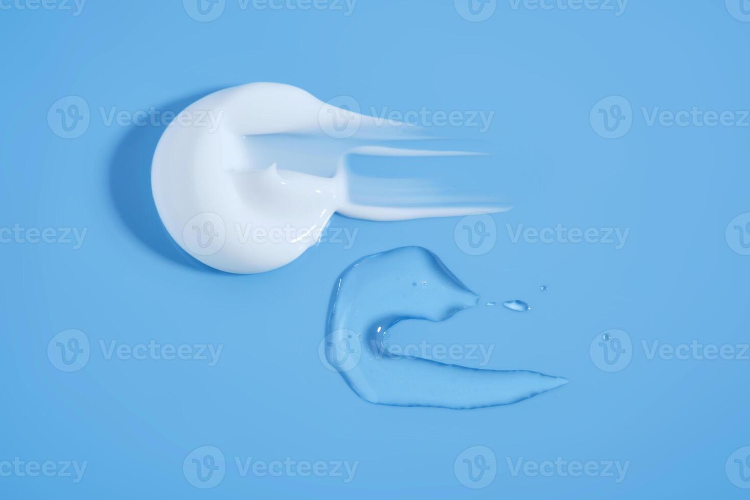 A smear of white cream And a drop of serum on a blue background. photo
