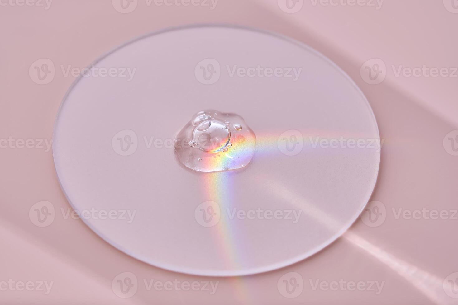 A drop of serum on a round stand on a pink background with beautiful caustics. photo