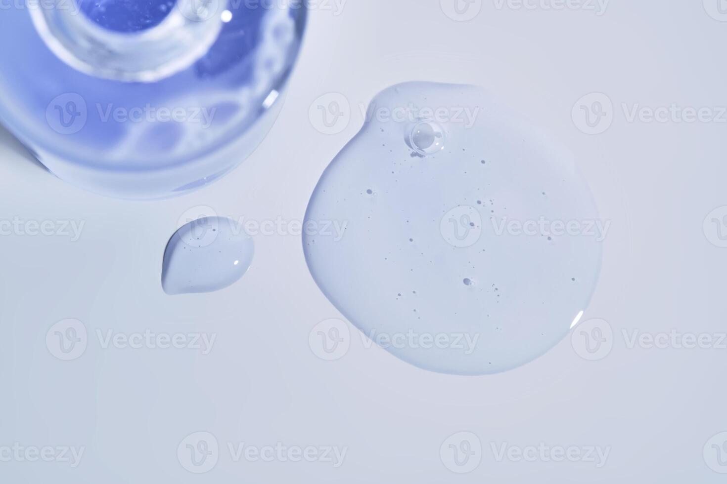 Cosmetic bottle and a drop of serum on a white background. photo