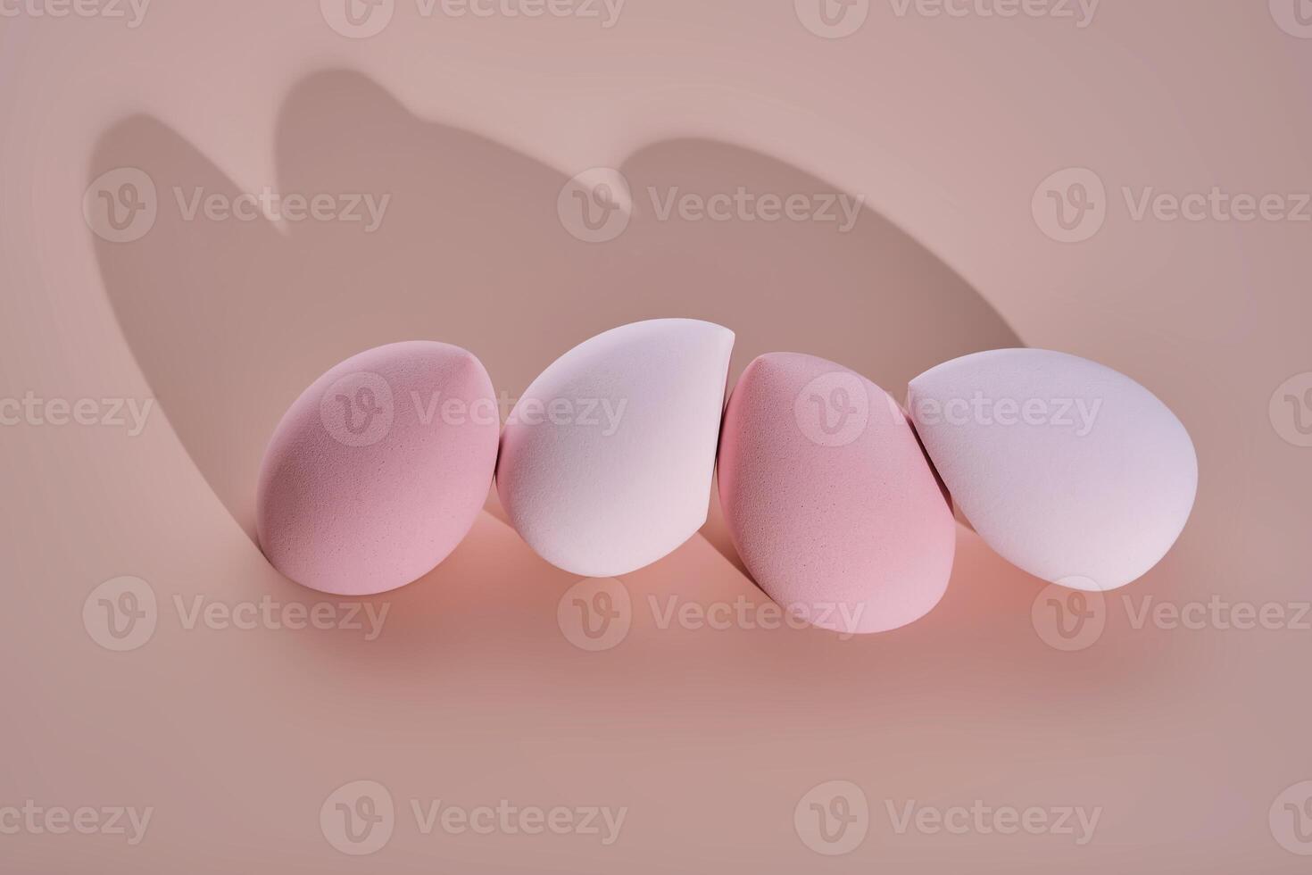 A set of makeup sponges on a pink background. photo