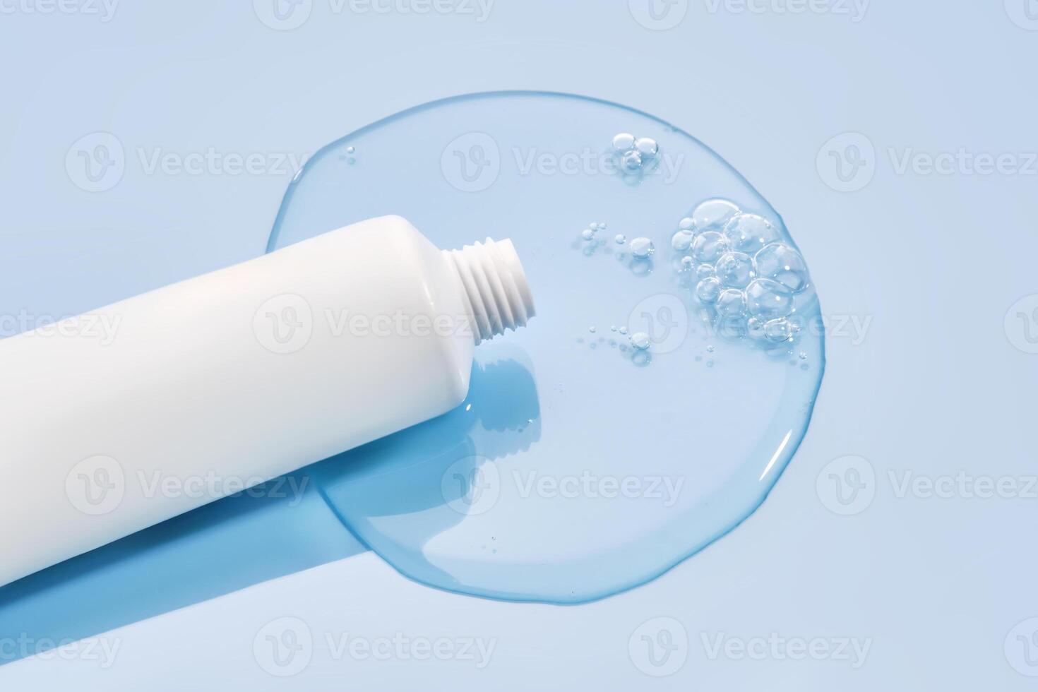 Shampoo pouring out of a small tube on a blue background. Texture. photo