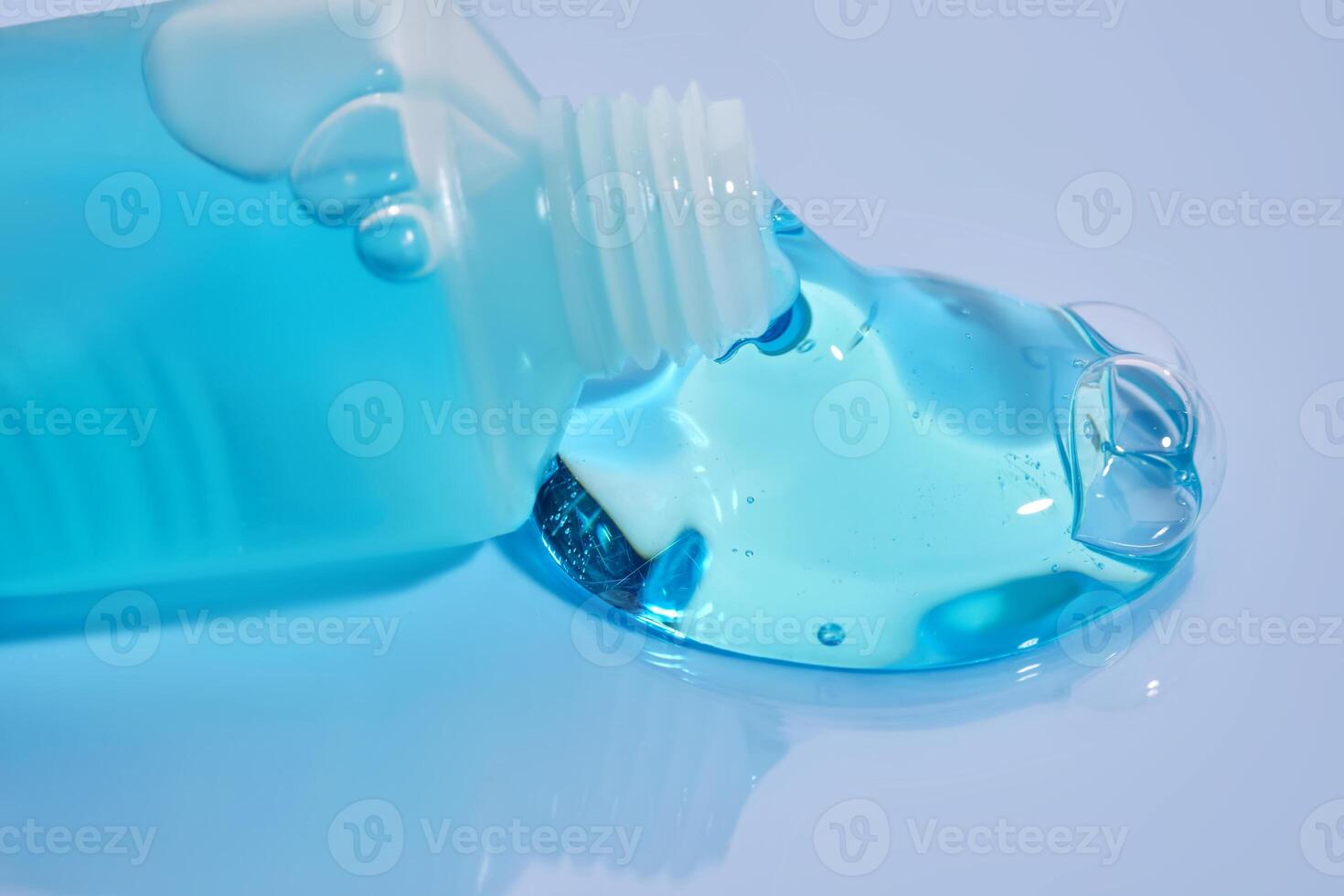 Shampoo pouring out of a small tube on a blue background. Texture. photo