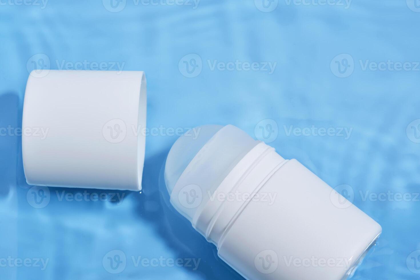 Roll-on deodorant on a blue background in water. photo
