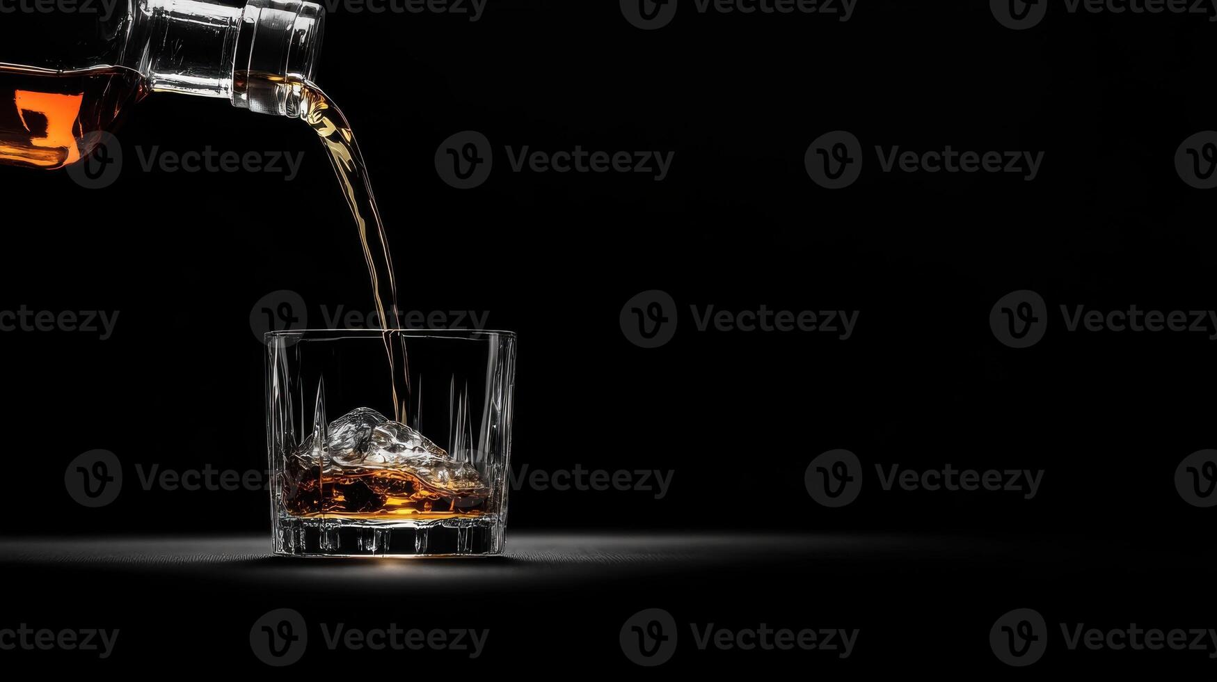 Whiskey pouring into a glass on a black background photo