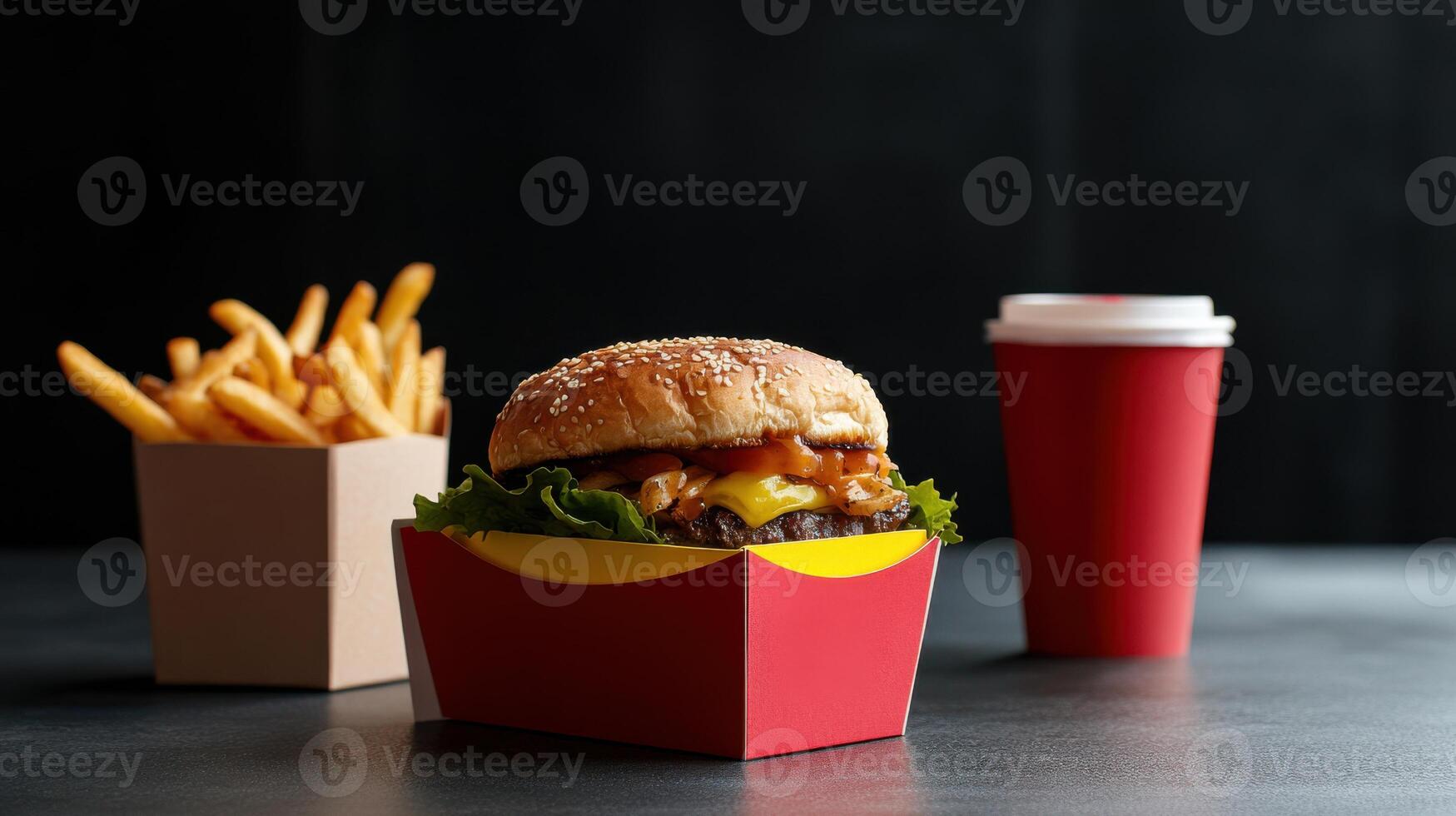 A hamburger and fries in a box with a cup of coffee photo