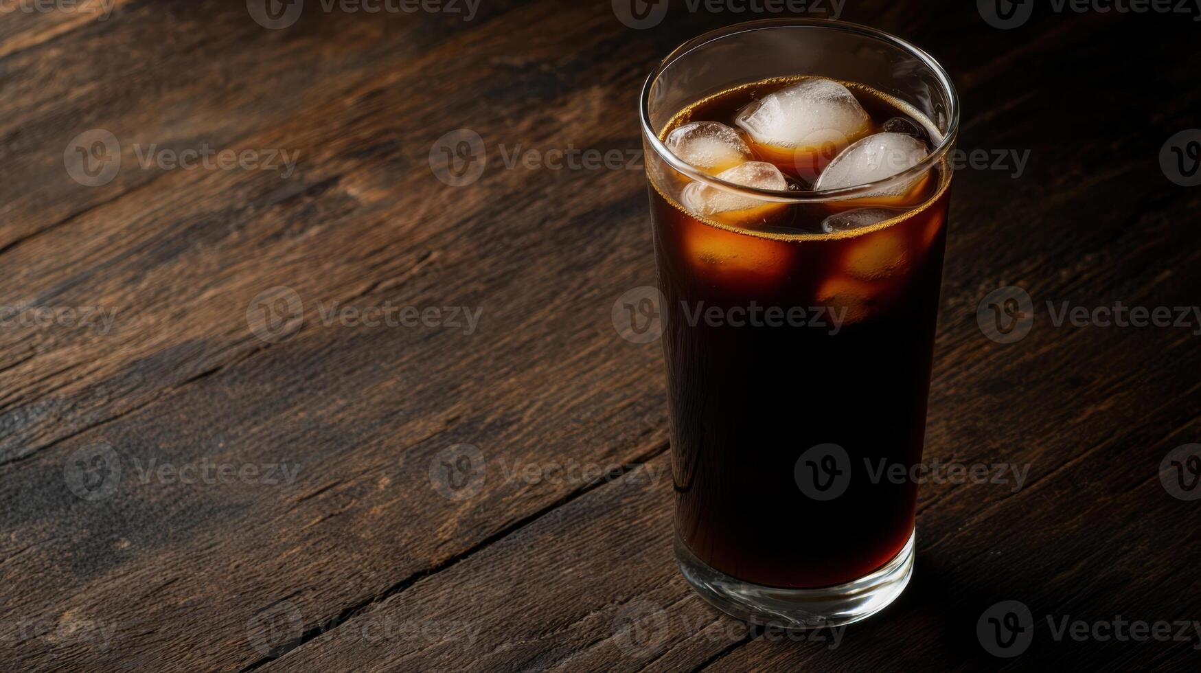 Freshly brewed cold brew coffee in clear glass with ice cubes photo