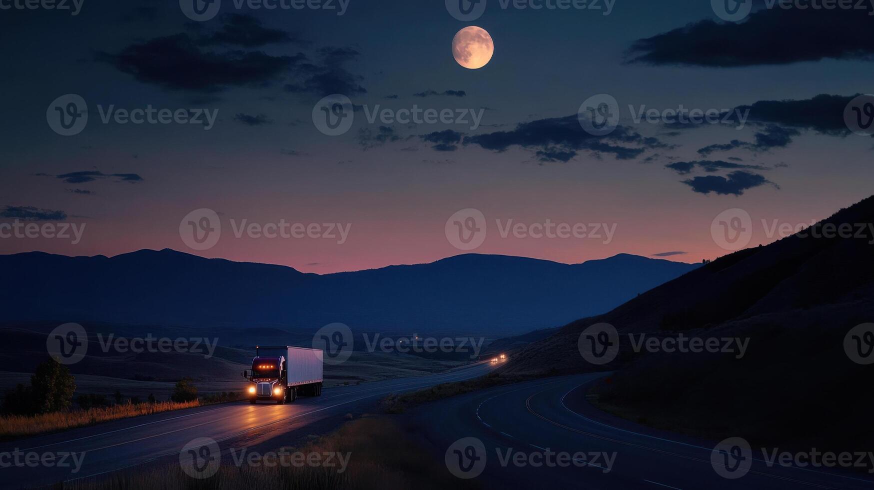 A semi truck driving down a road at night photo