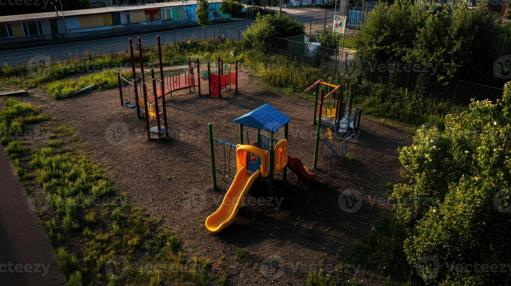 playground with colorful equipment in neglected area, surrounded by overgrown grass photo