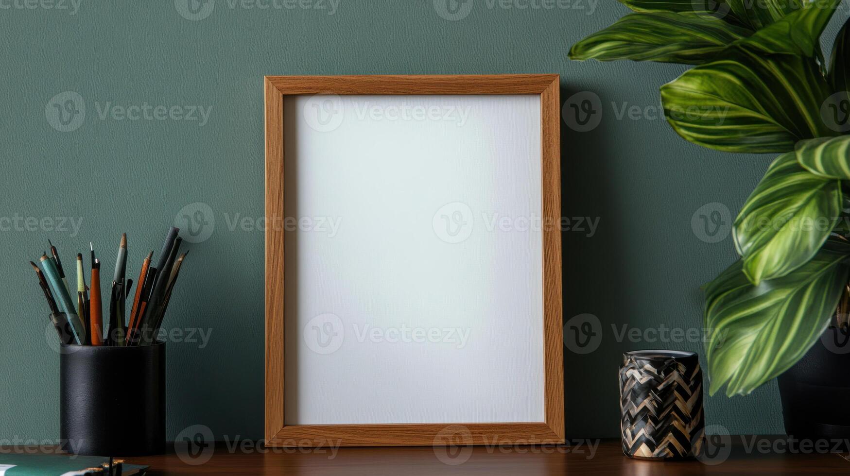 Empty wooden frame on desk with plants and stationery photo