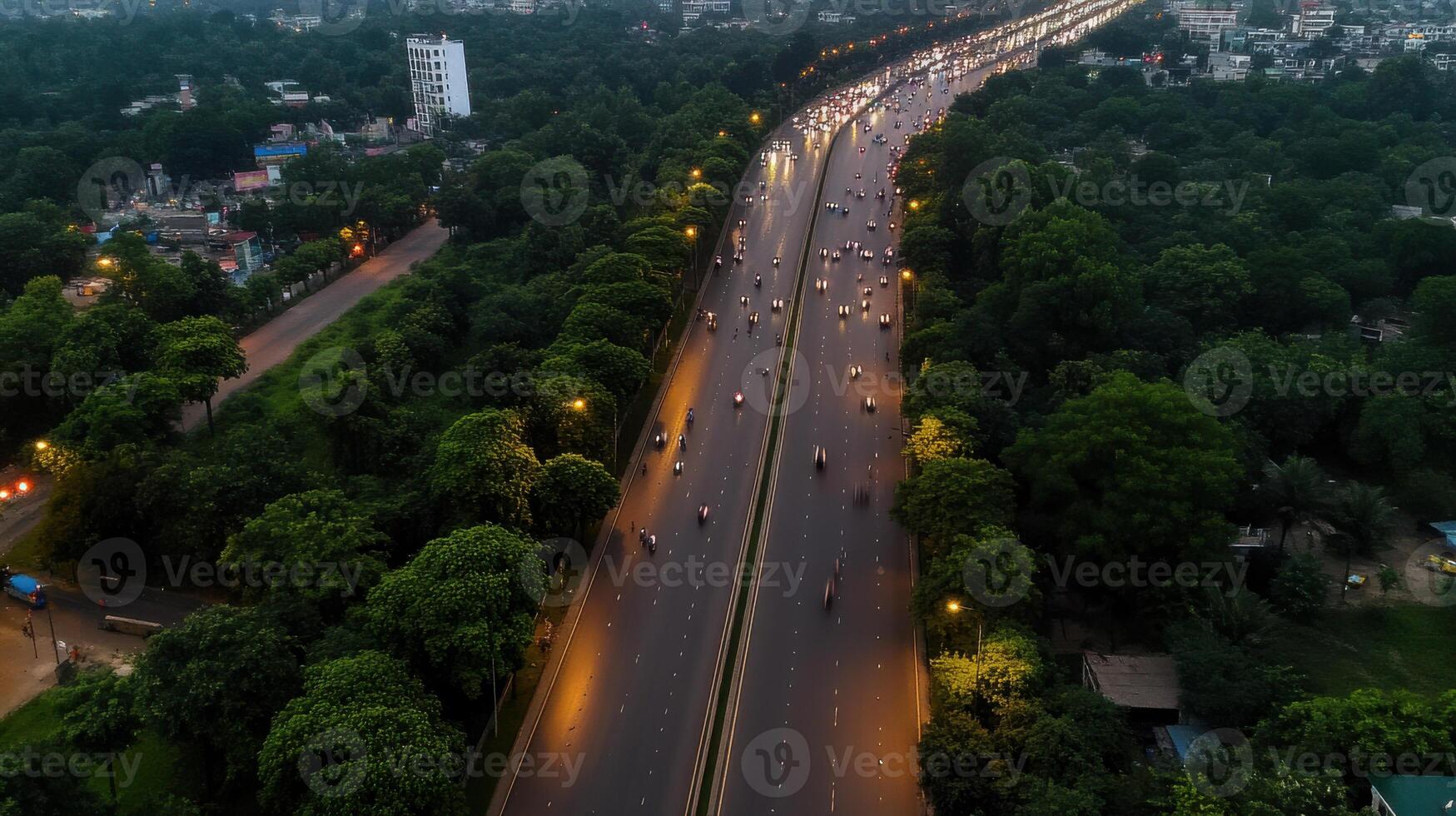Aerial view of busy highway surrounded by greenery at dusk photo
