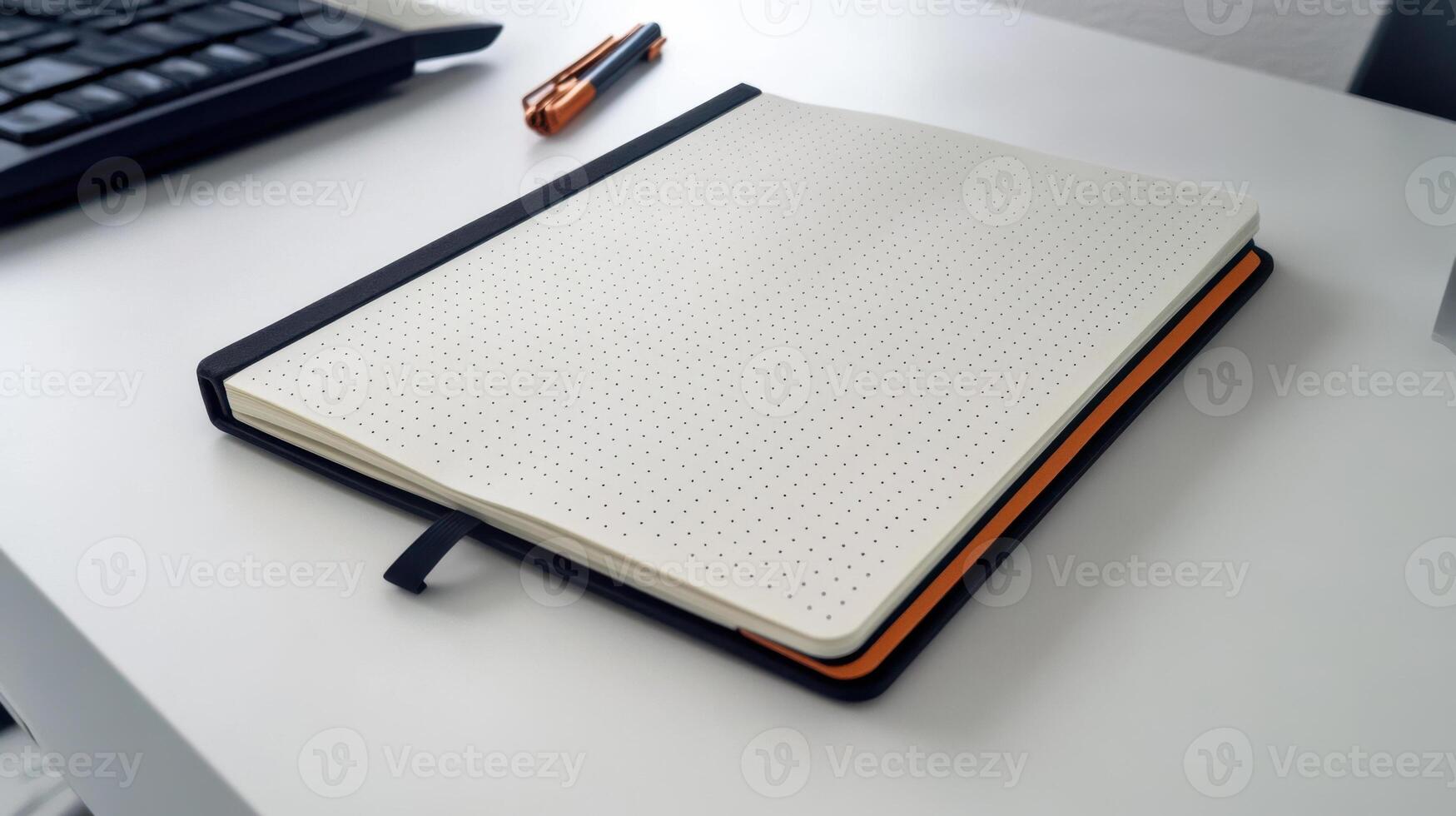 A notebook on a desk with a keyboard and mouse photo