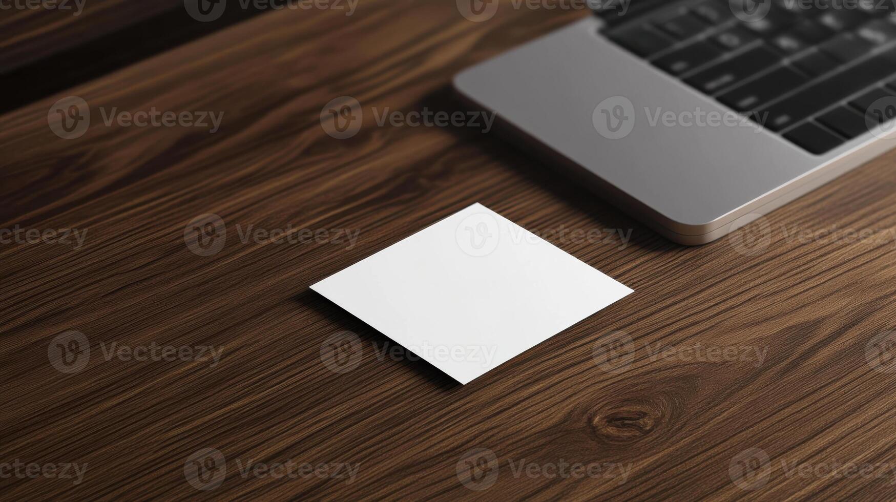 blank business card on wooden desk beside laptop photo