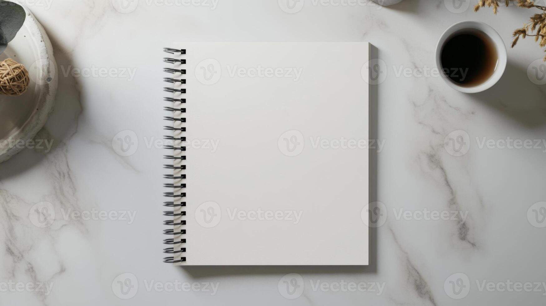 Minimalist spiral notebook on marble surface with coffee photo
