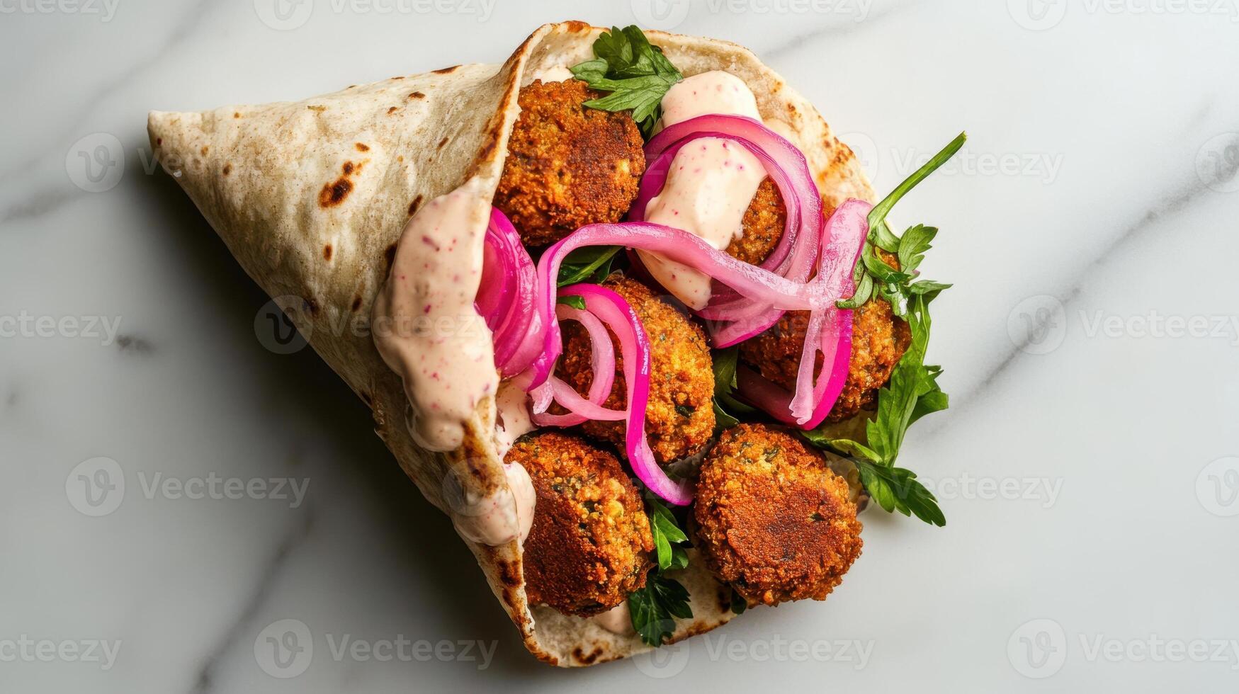 Crispy falafel wrap with pickled onions and tahini sauce photo