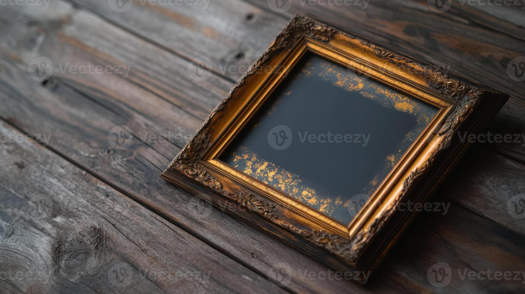 An old gold frame sitting on a wooden table photo