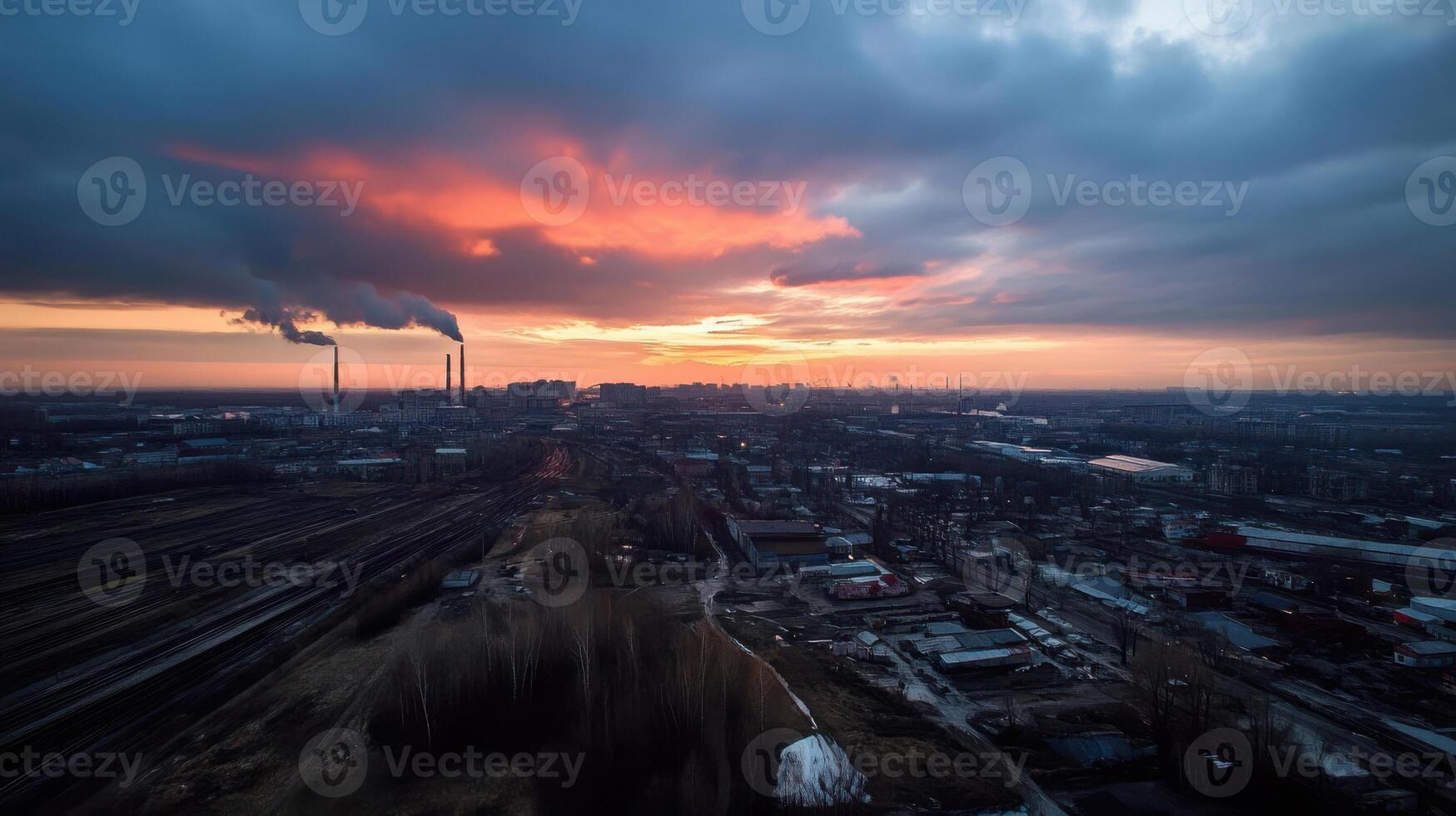 Industrial city skyline at sunset with smoke and clouds photo