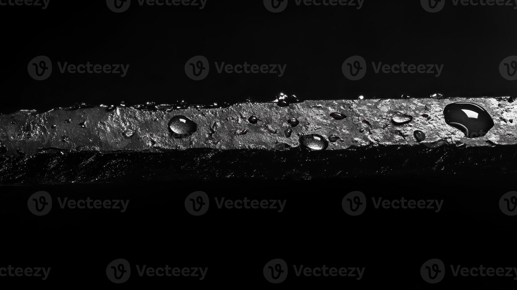 Close-up view of a wet surface with water droplets captured in dramatic lighting showcasing texture and depth photo
