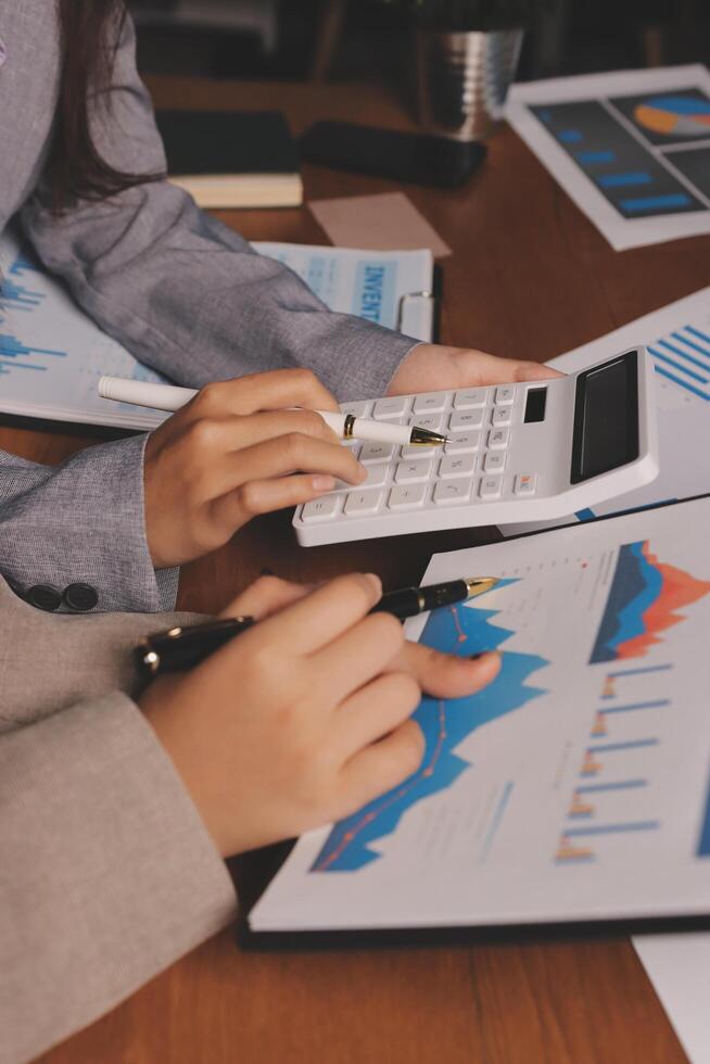 Two people are working on a calculator and a paper photo