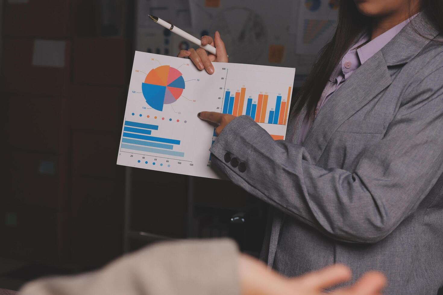 A woman in a business suit holding a clipboard with graphs on it photo