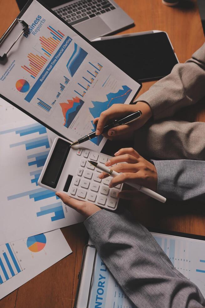 Business people working on a calculator and papers photo