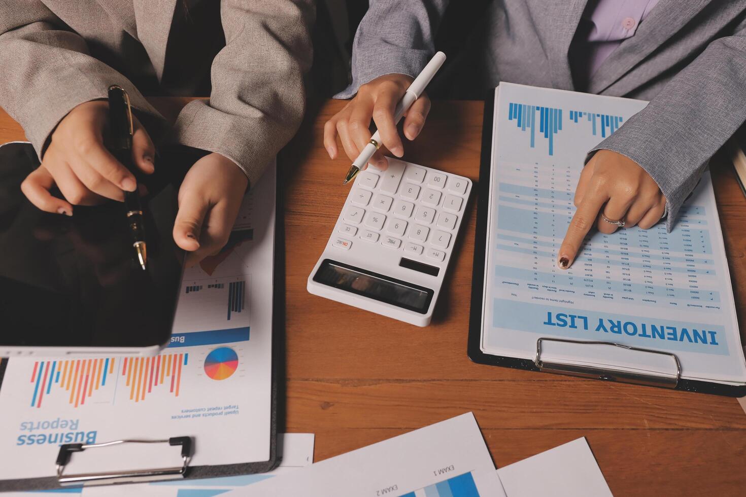 Business people working on paperwork and a calculator photo