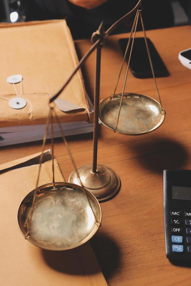 A scale of justice on a desk with a calculator and papers photo