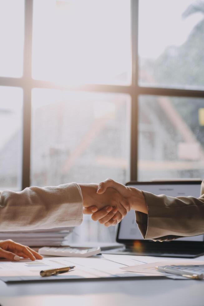 Two business people shaking hands over a table photo