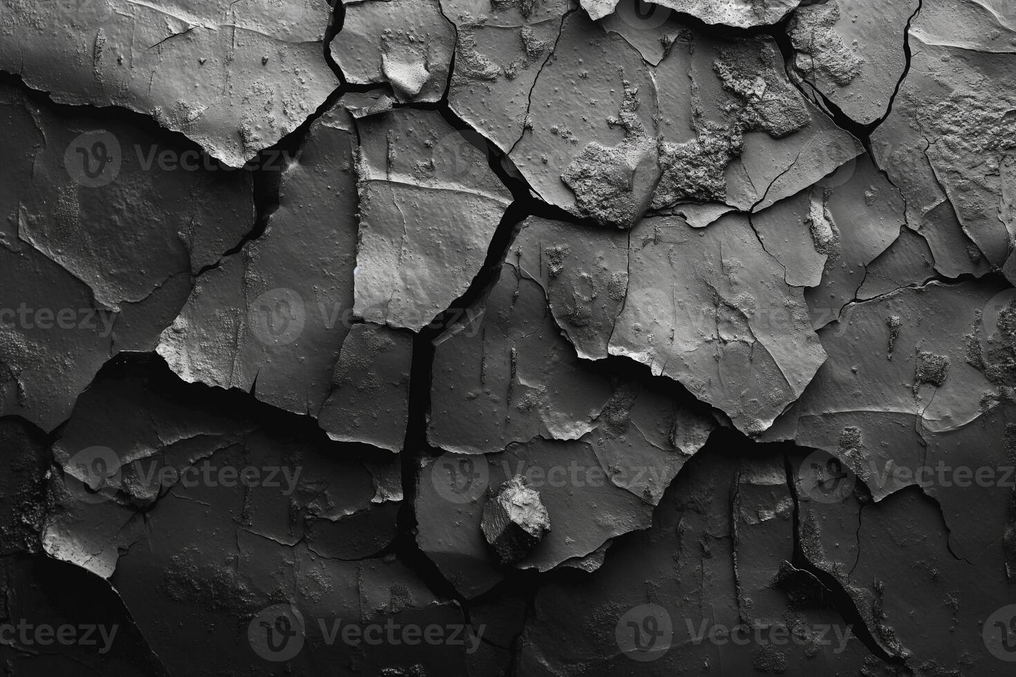 Close-up of textured cracked black paint on a surface, showcasing a variety of shades and patterns. photo