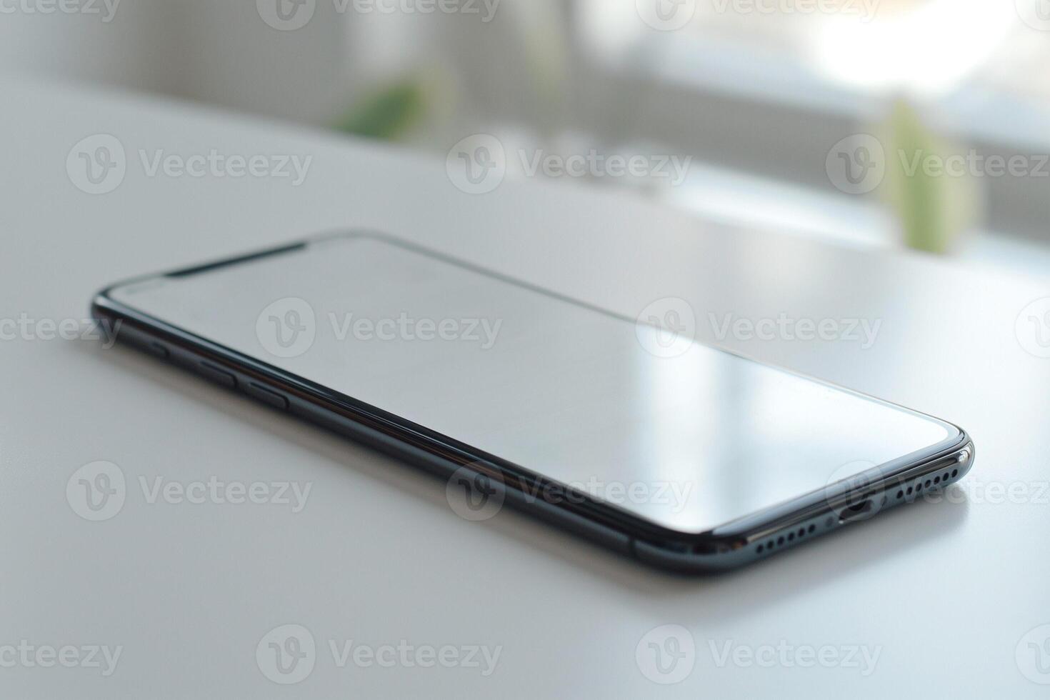 A sleek smartphone sits on a clean surface, reflecting light in a modern and minimalistic setting. photo