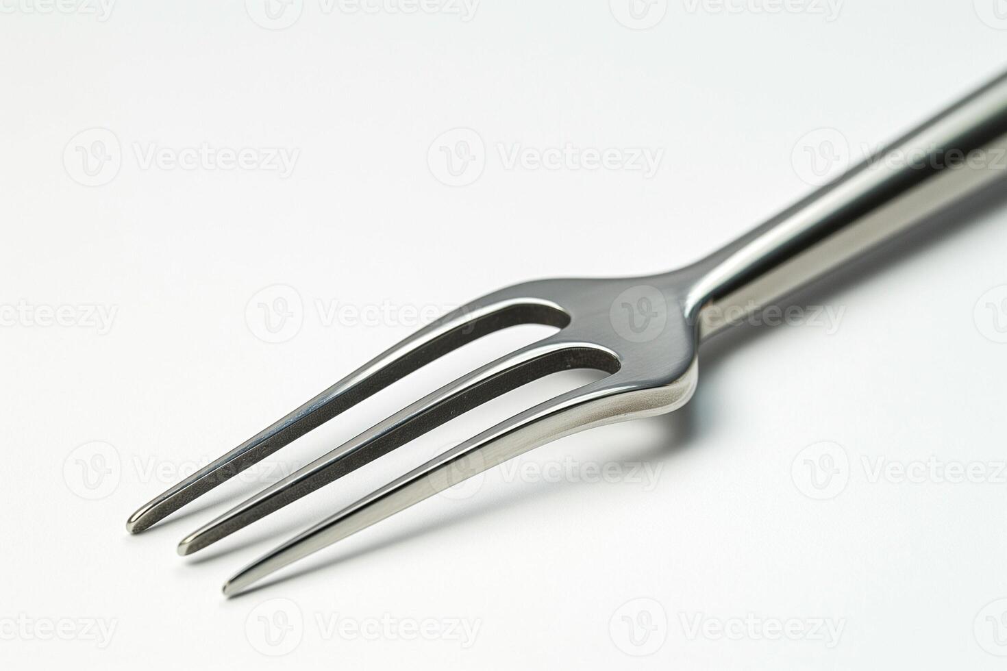 Close-up of a shiny stainless steel fork with three prongs, perfect for culinary settings. photo