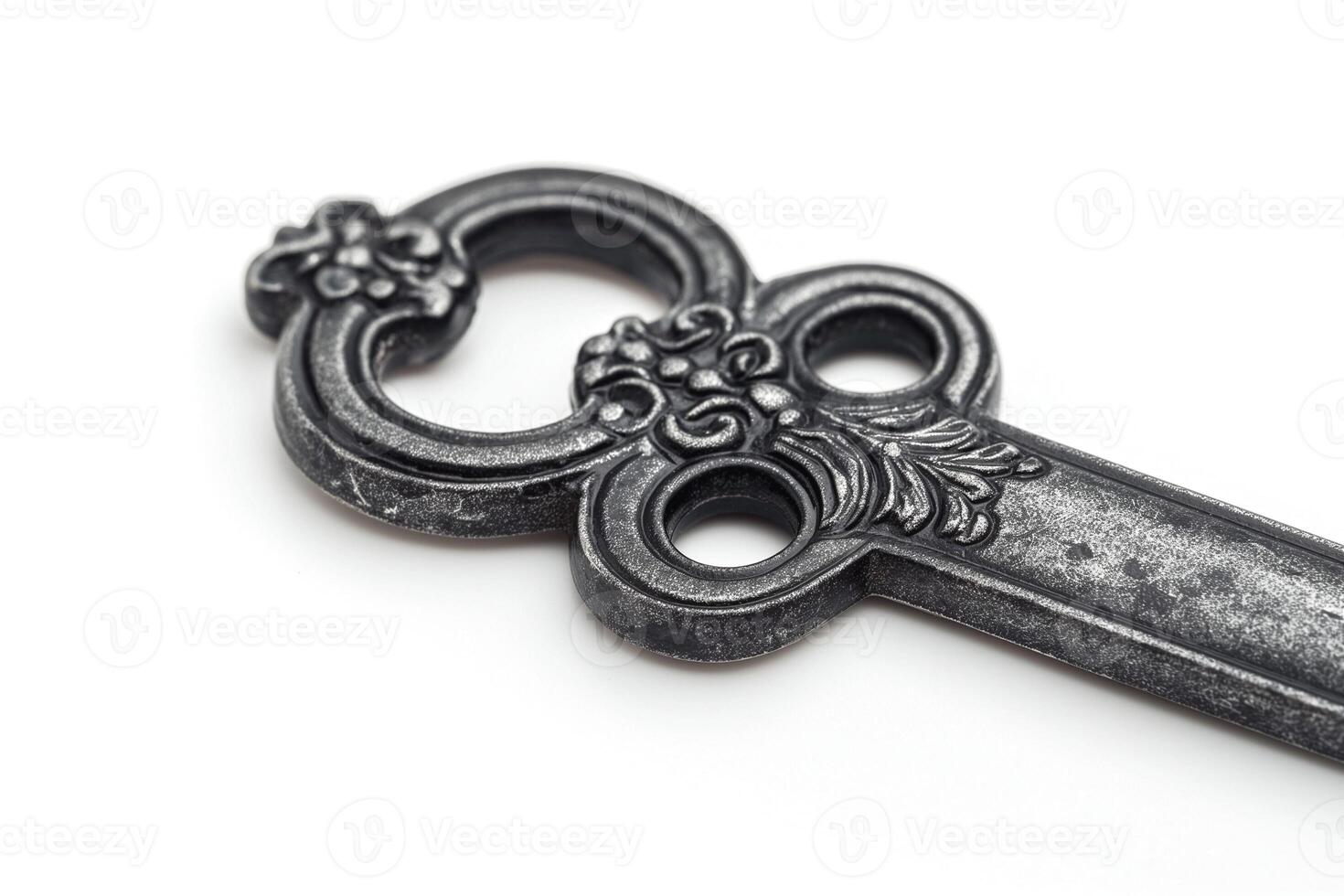 A close-up of an ornate, vintage black key featuring intricate floral designs. photo