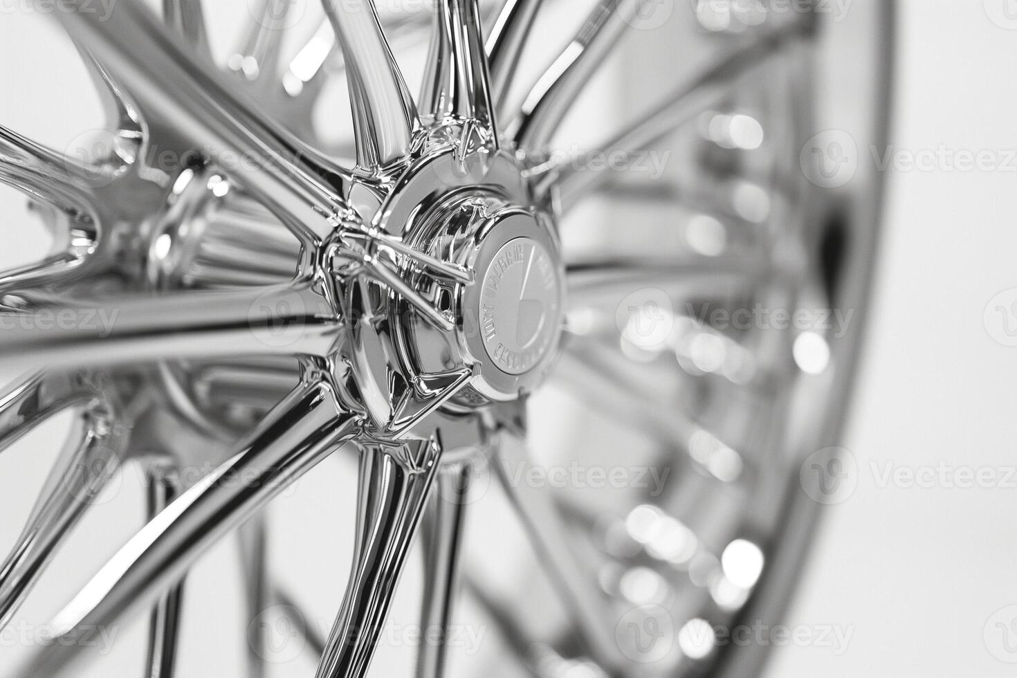 Close-up of a shiny chrome car wheel, showcasing intricate spokes and a polished surface. photo