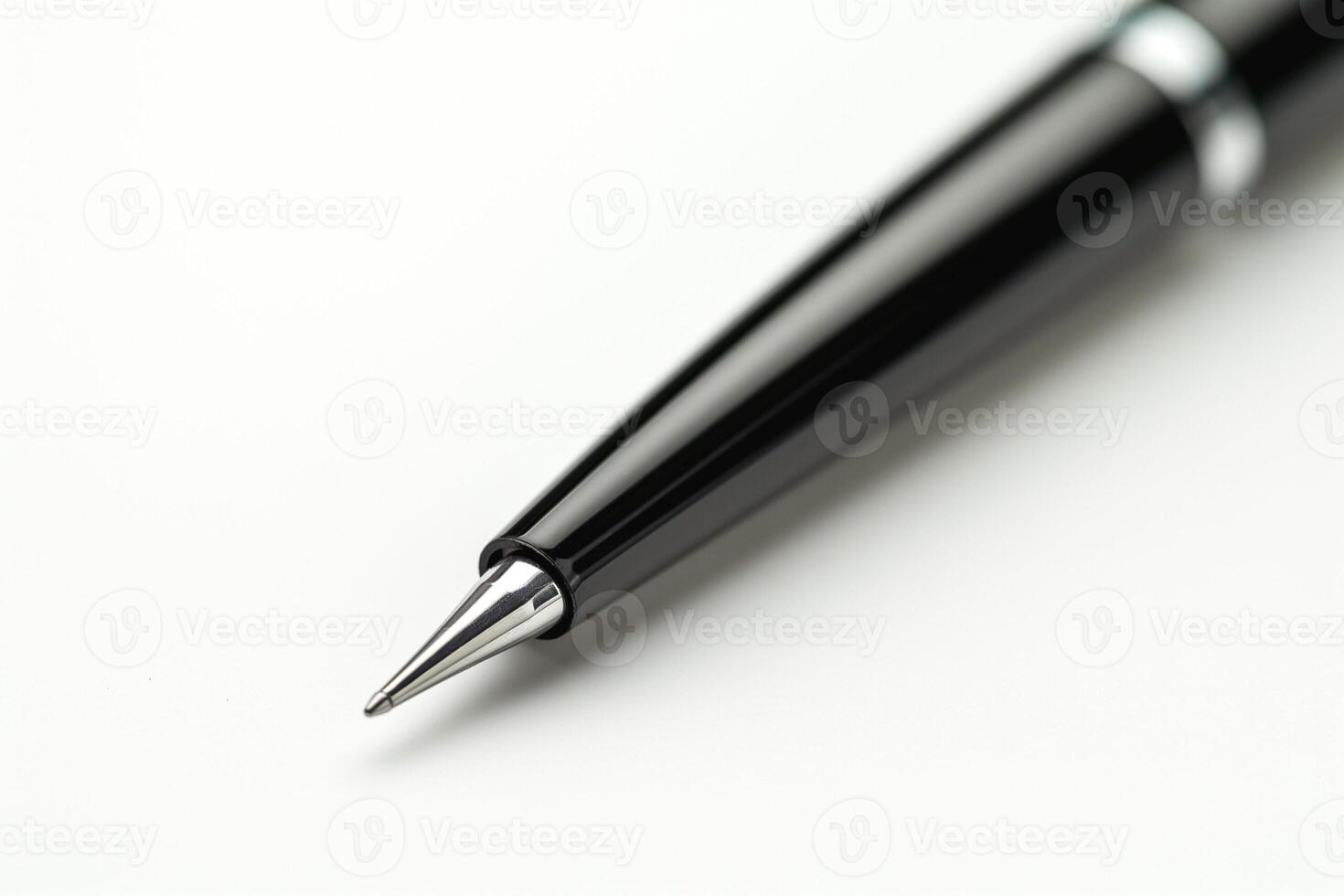 Close-up of a sleek black ballpoint pen, showcasing its elegant design and shiny chrome tip. photo