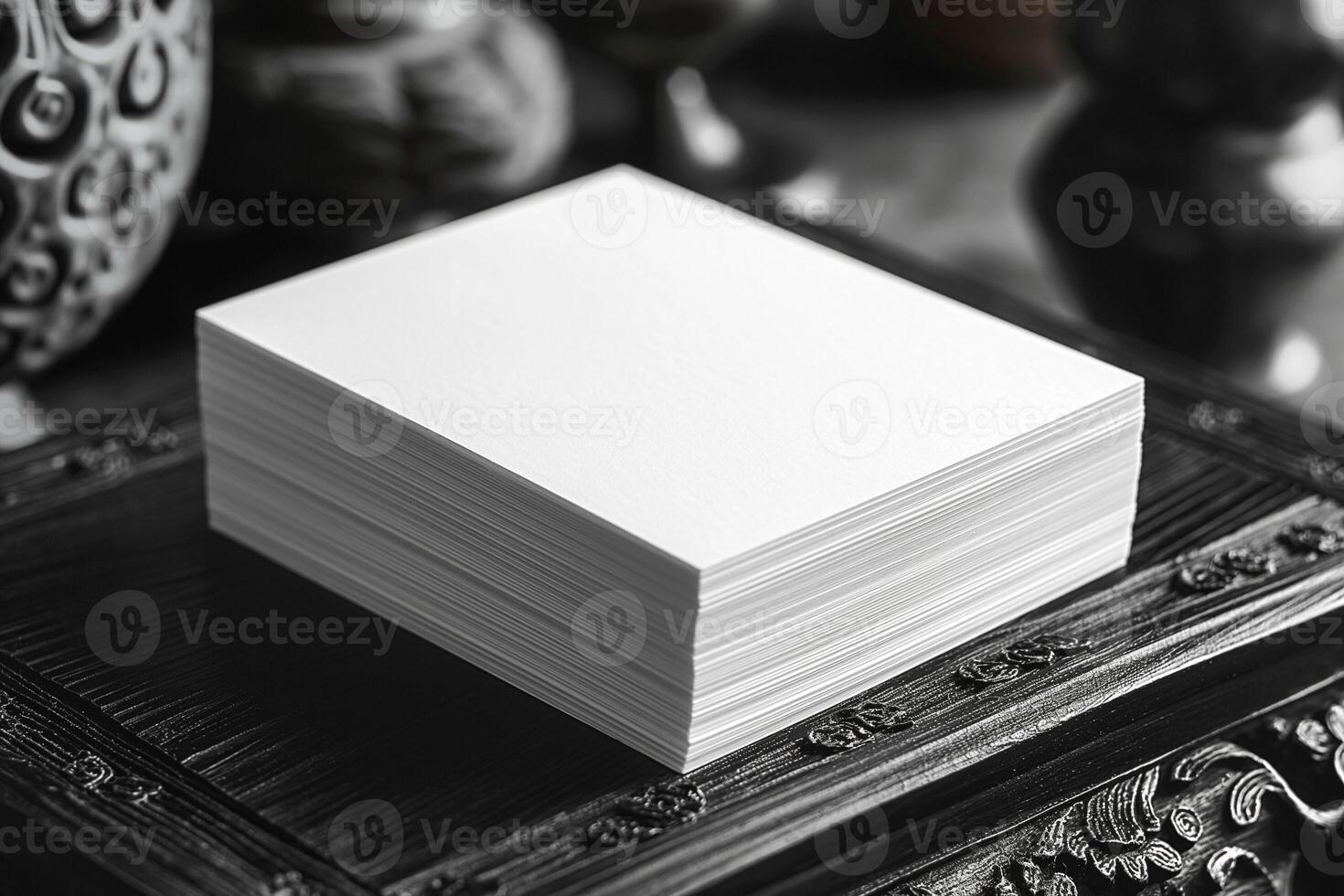 A stack of pristine blank business cards on an ornate dark wood surface, perfect for customization. photo