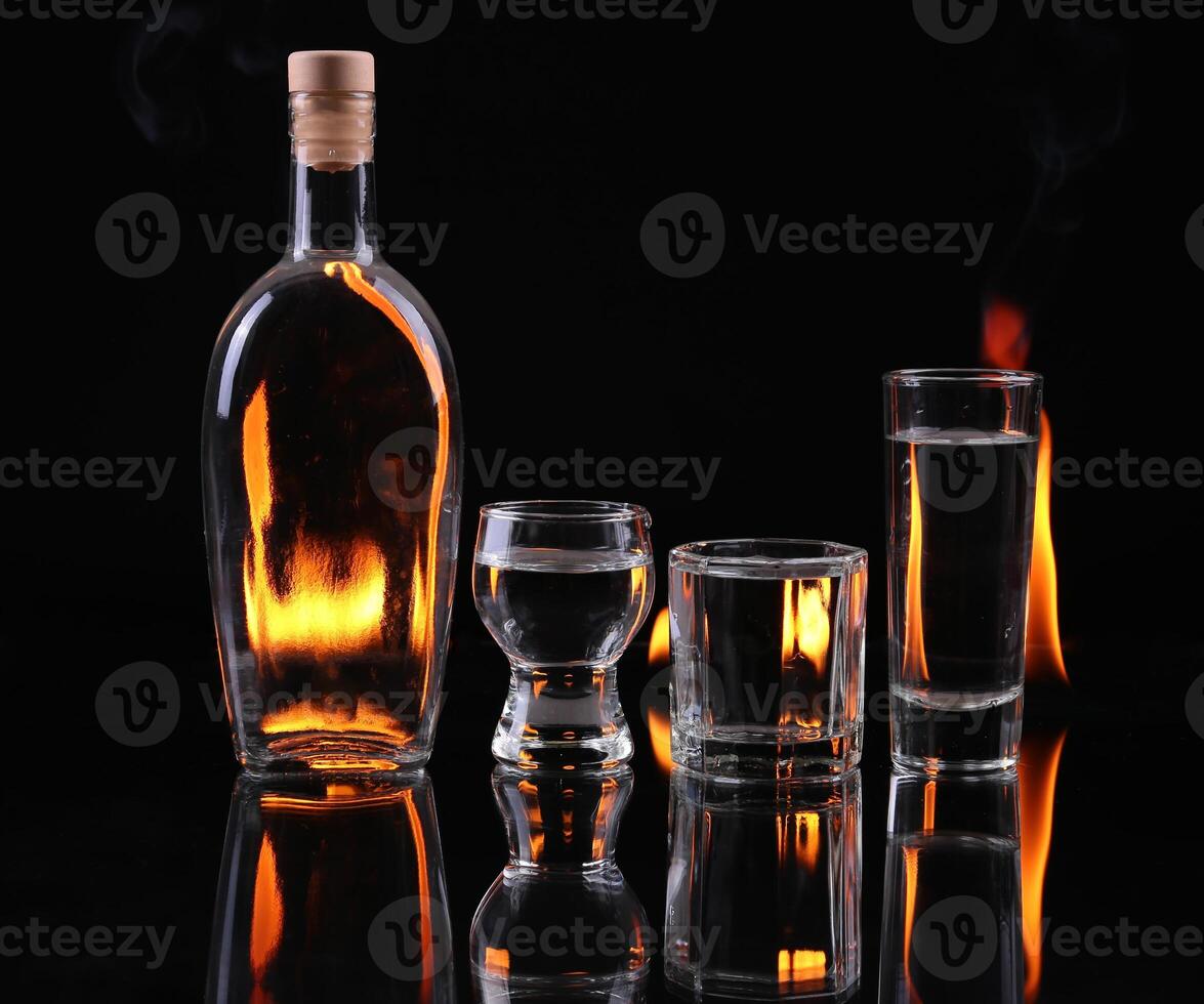 Stack of tequila on fire over black photo