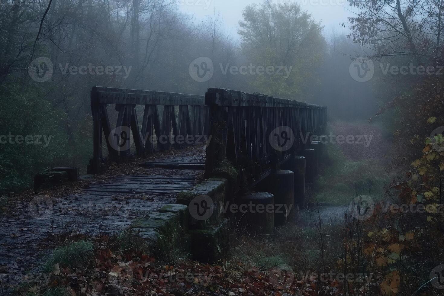 Old wooden bridge disappearing into the fog in a forest during a misty autumn morning photo