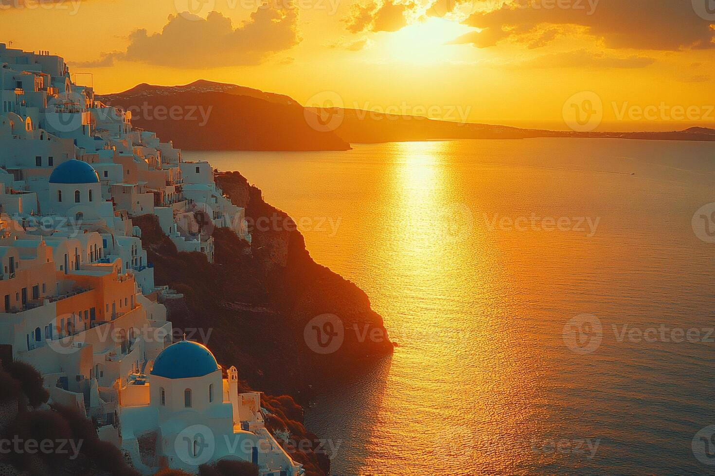 Golden sunset illuminating white houses and blue domed churches of Oia, Santorini, Greece photo