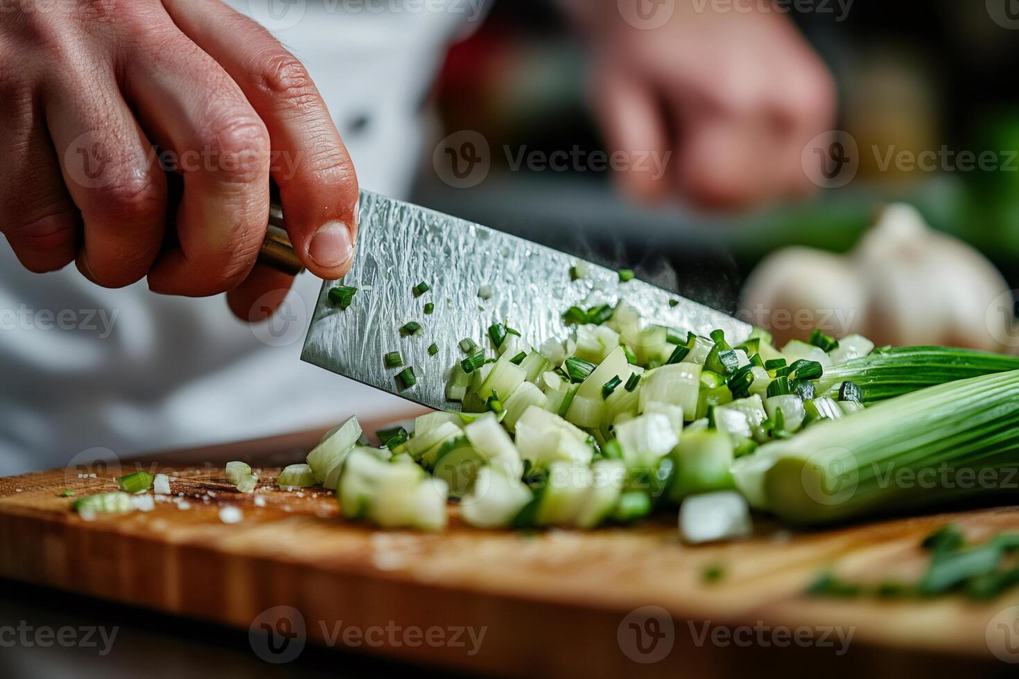 Chef chopping fresh leek on wooden cutting board photo