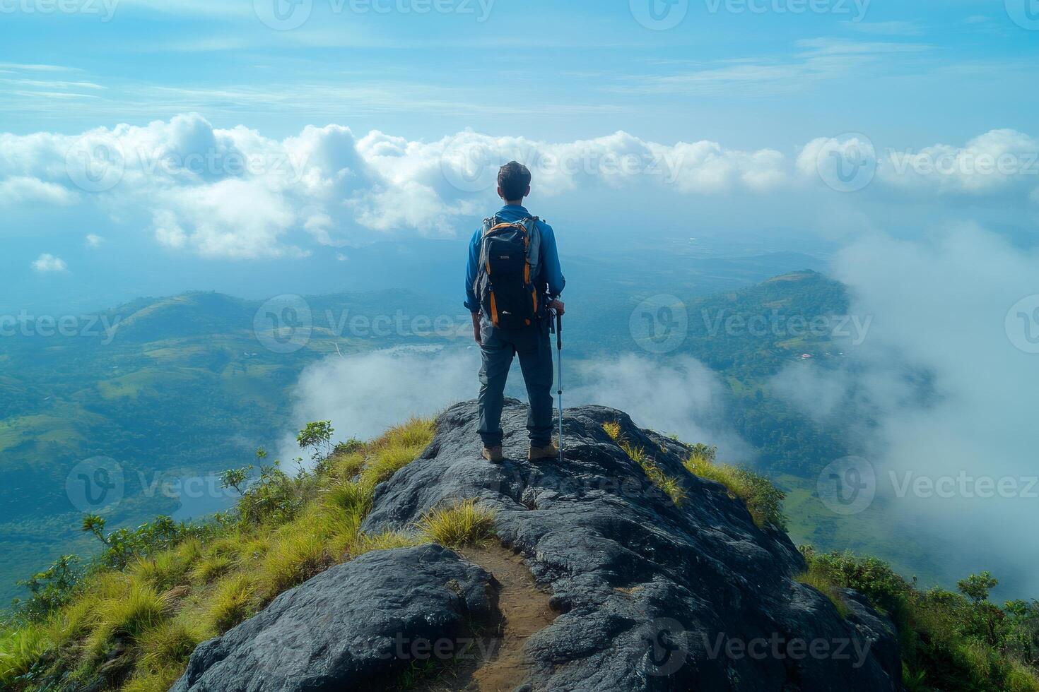 Hiker standing on top of mountain enjoying breathtaking view above clouds photo