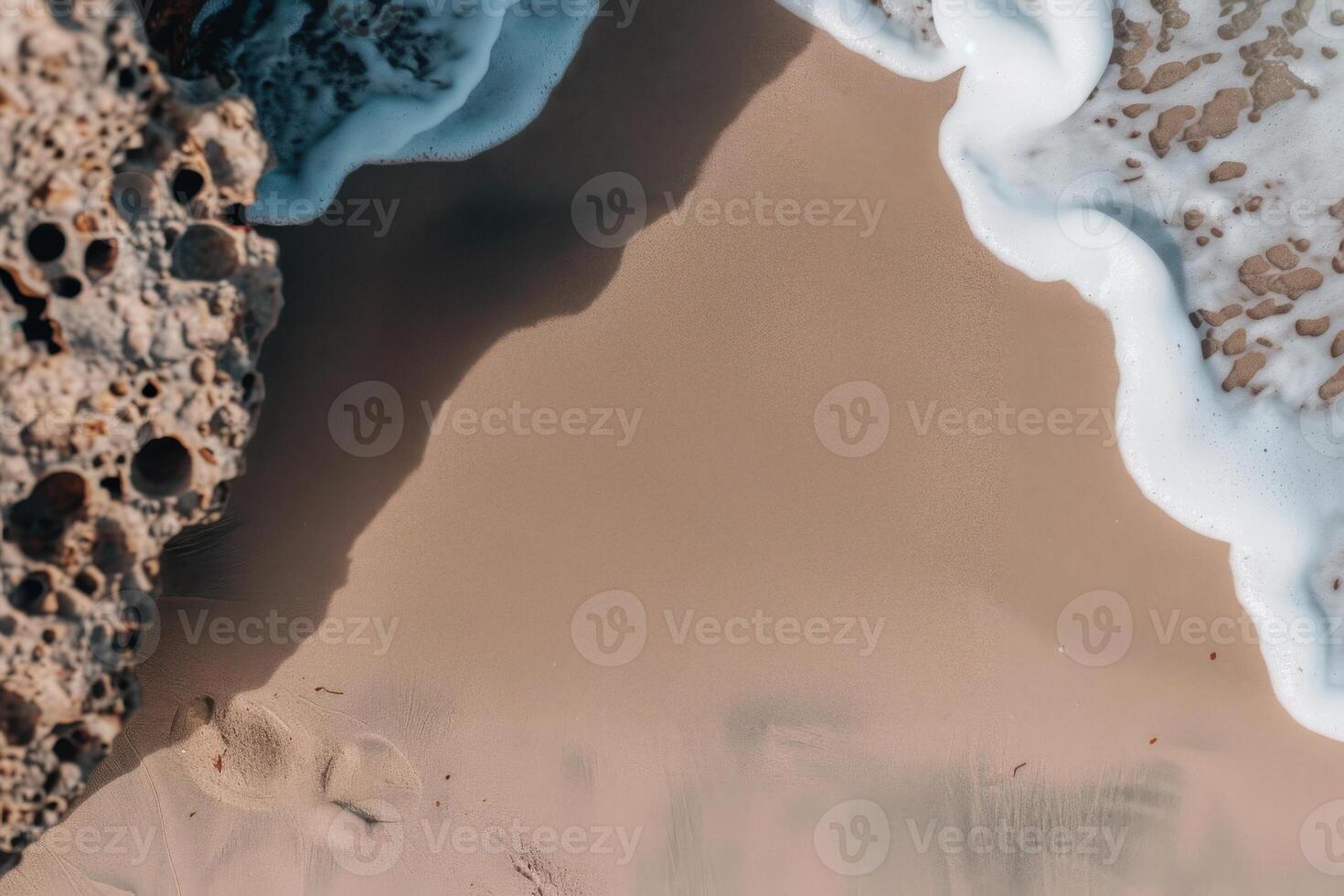 Waves gently wash over smooth sandy shorelines near a textured rock photo