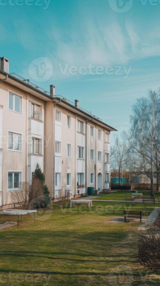 An apartment building with a lawn and trees photo