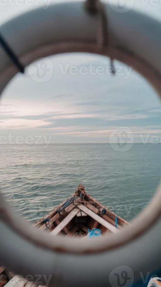 A view of the ocean through a circular porthole photo