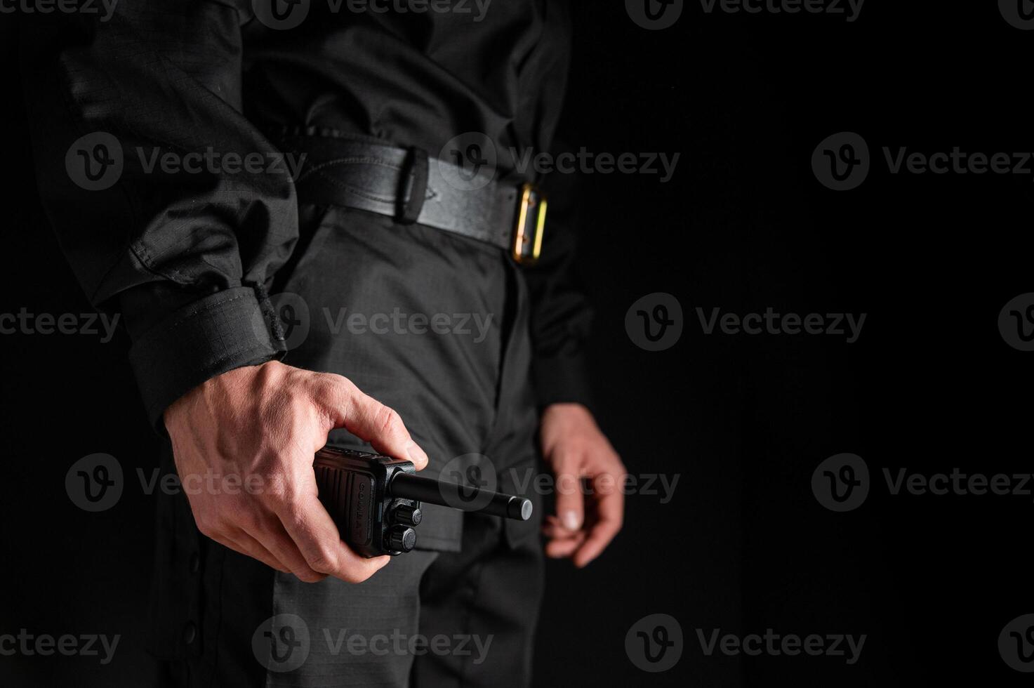 man holds a portable radio in his hand to communicate with other people. A method of communication during security duty photo