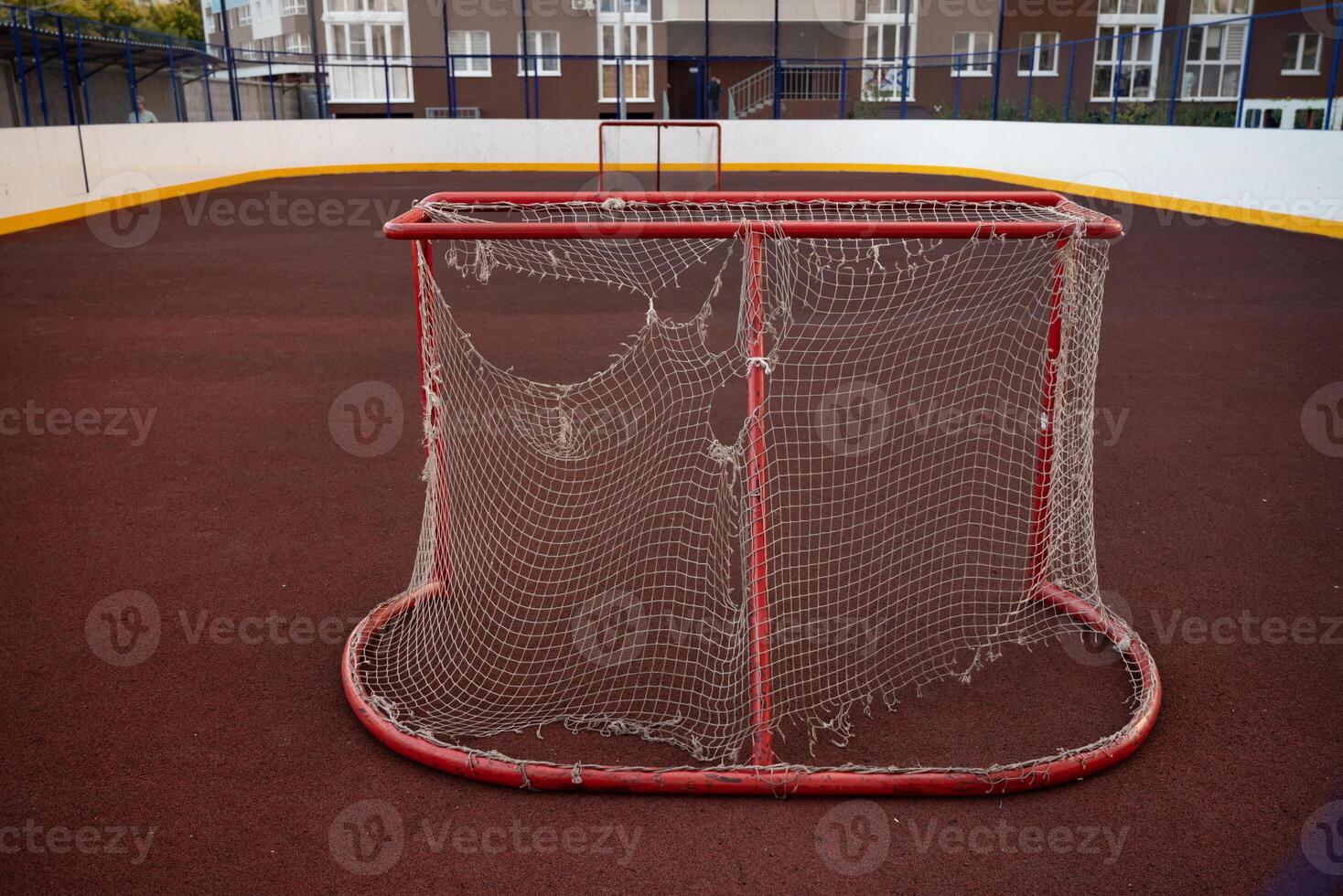 Broken goal net on village football field with sky in background photo