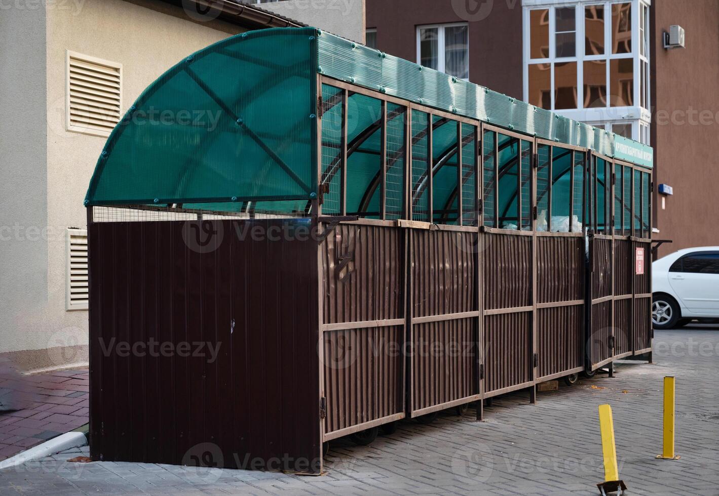 Six new plastic green garbage standard containers. Back side of the city sports festival. In the background - trading canvas tents photo
