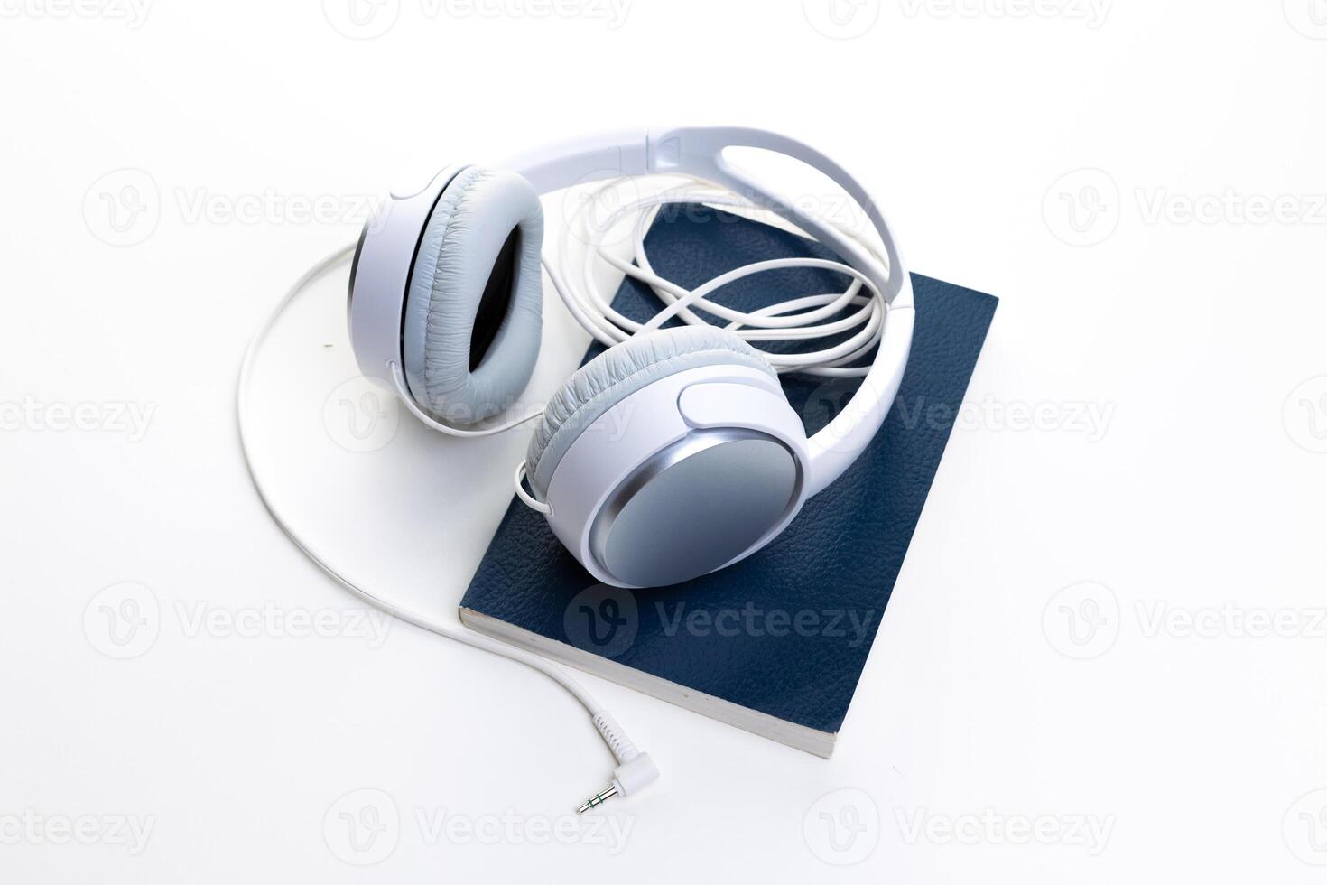 White headphones and notepad on white background photo