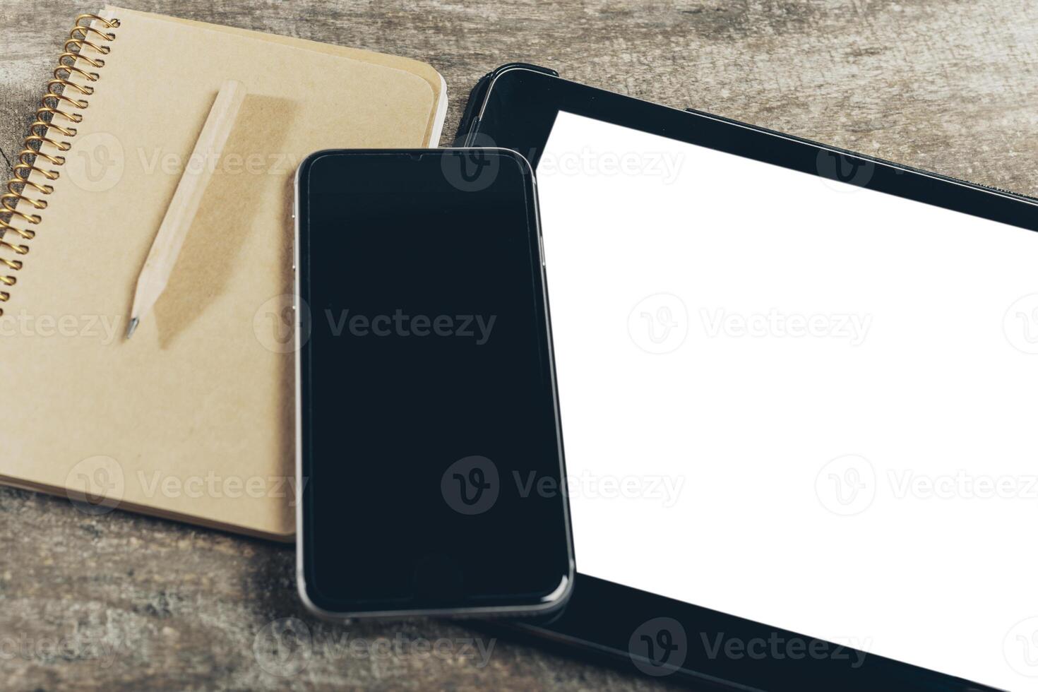 Close up of smartphone with notepad and drink on grunge wooden background photo