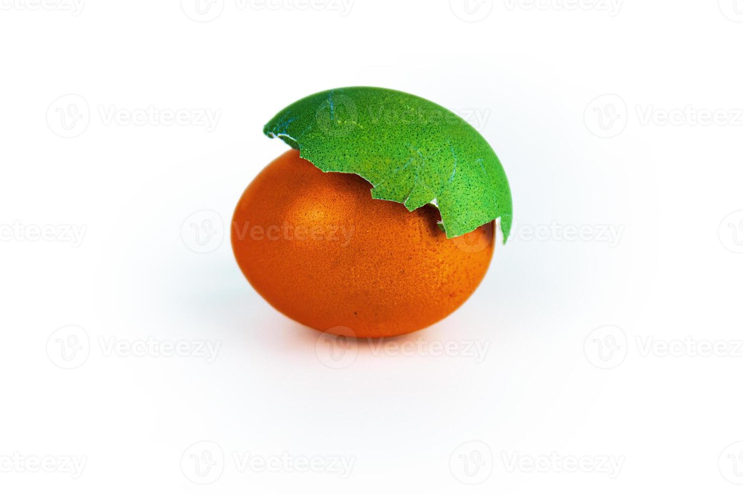 Easter egg composition with vivid orange egg covered with cracked green shell, isolated on white background. Contrast color combination, creativity, holiday decoration. Selective focus photo